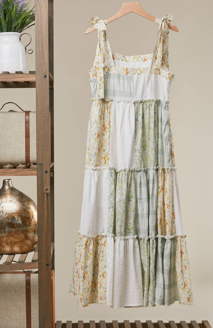 Floral tiered dress hanging on a wooden hanger against a neutral background