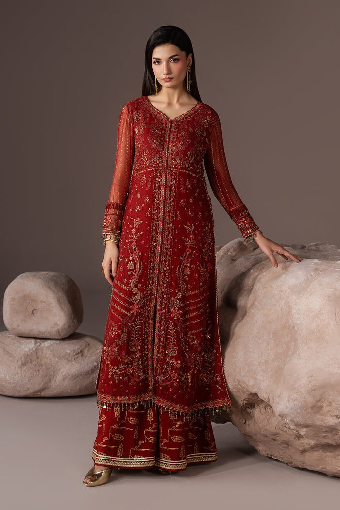 Three-quarter view of Rayaleen showing the rust orange embroidered gown, flared pants and draped Net dupatta.