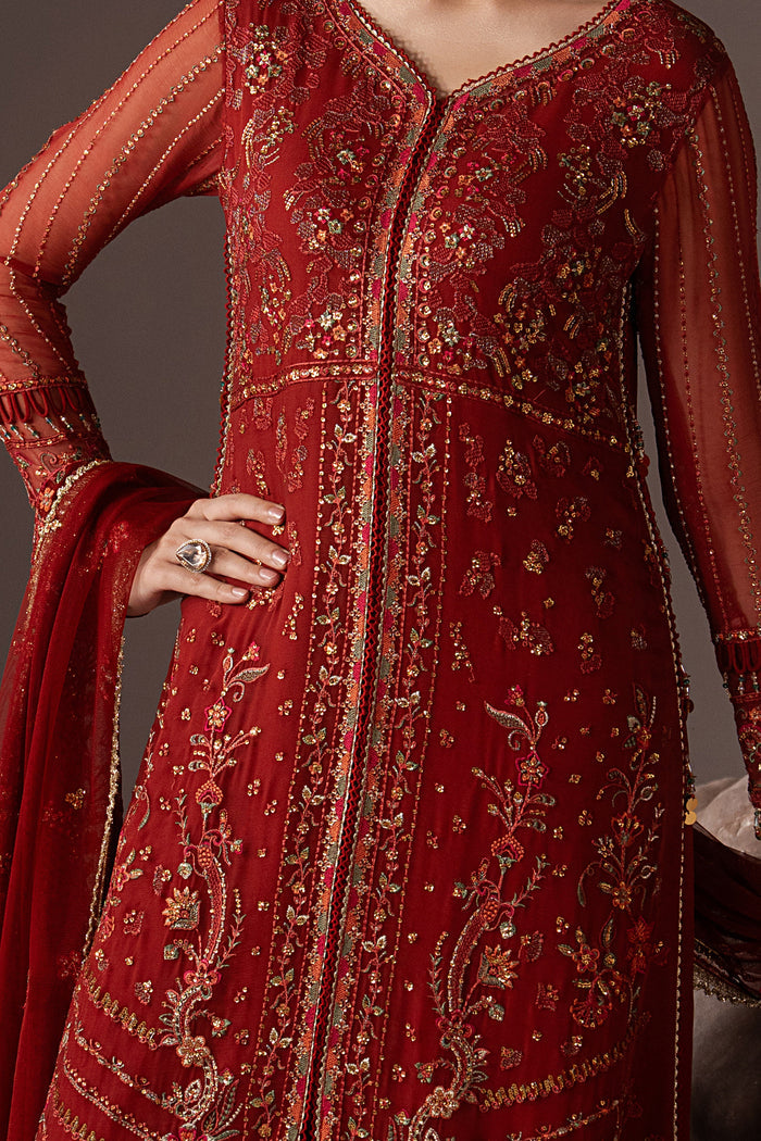 Close-up of Rayaleen showing the embroidered neckline, sequins and detailed embellishment on the rust orange Crinkle gown.