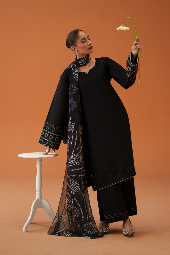 Model wearing Riedel black embroidered lawn outfit with printed crinkle chiffon dupatta, styled as a ready-to-wear semi-formal Eastern dress.