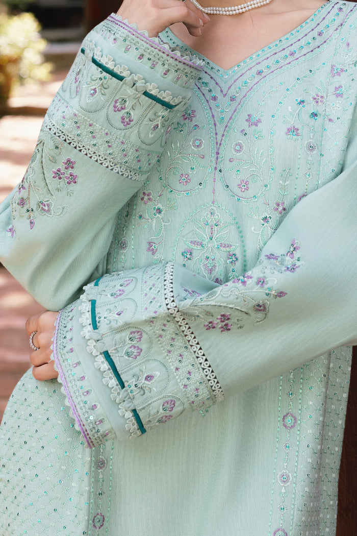 Light green traditional outfit with floral patterns and embroidery.