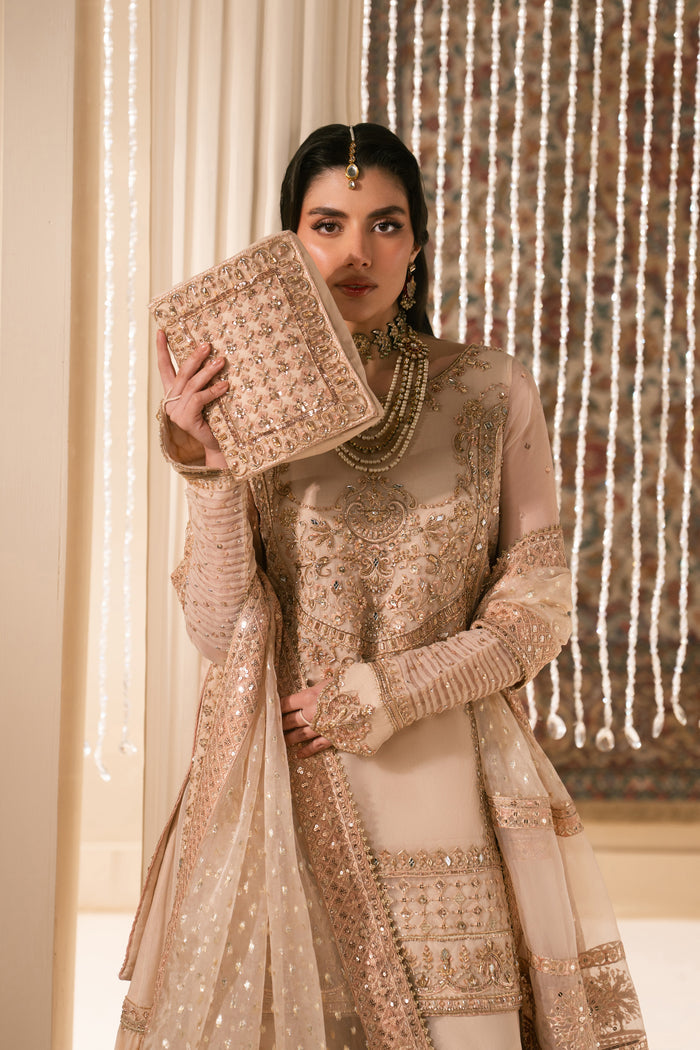 Close styling shot of Tizmat peach bridal outfit highlighting embroidered shirt front, delicate organza dupatta drape and matching pouch, elegant Nikkah ready to wear dress.