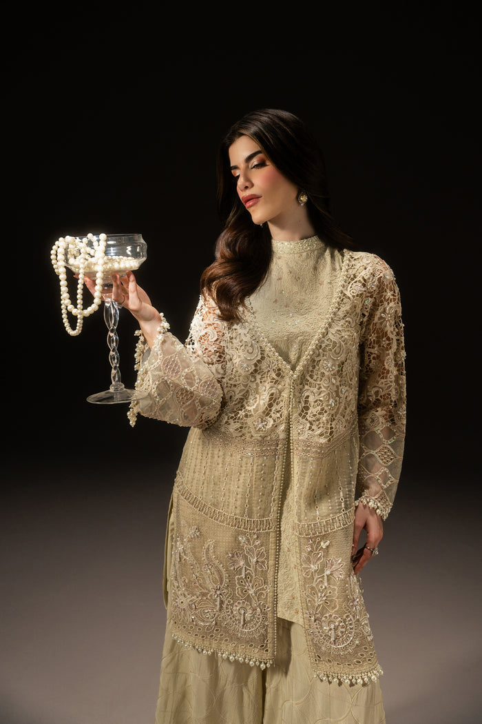 Three-quarter view of Varena featuring the off-white embroidered Organza shirt, clean neckline and detailed flared sleeves.