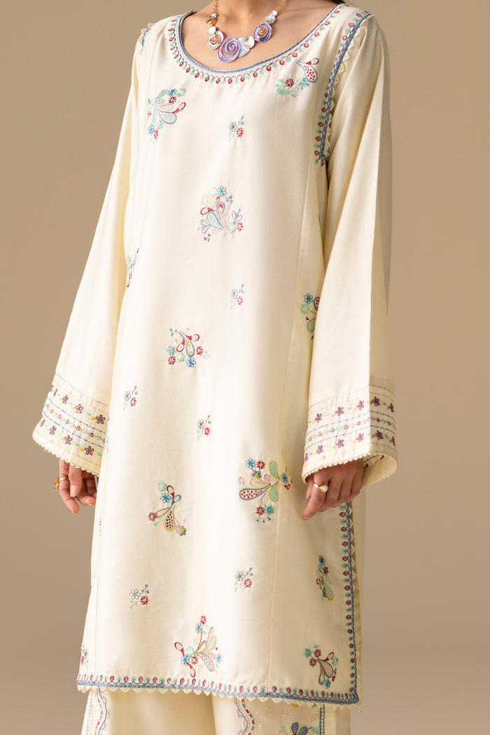 Close front view of Willow Cream White shirt showing embroidered boat neckline, floral motifs and loose sleeves.