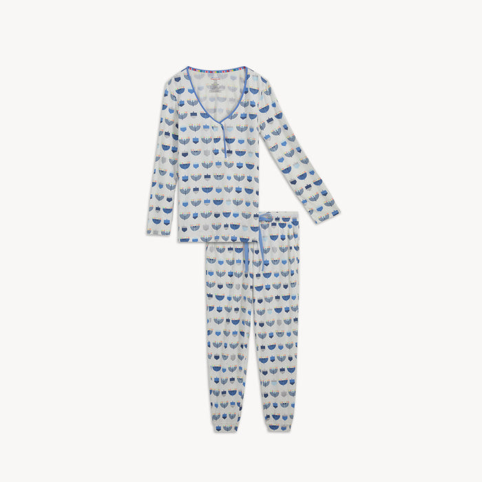 An ivory women's magnetic long-sleeve pajama top and jogger pants set featuring an all-over Hanukkah print with blue menorahs and dreidels, by Magnetic Me.