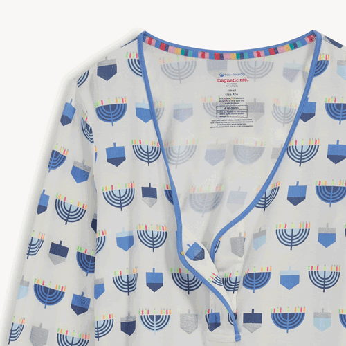 Open and close movement of the magnet at the top of An ivory women's magnetic long-sleeve pajama top and jogger pants set featuring an all-over Hanukkah print with blue menorahs and dreidels, by Magnetic Me.