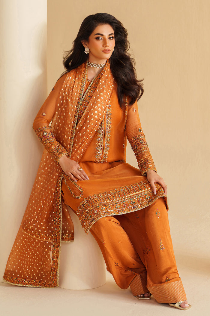 NAQSHI burnt orange ready-to-wear formal outfit styled in seated pose, showing graceful fall and refined festive look