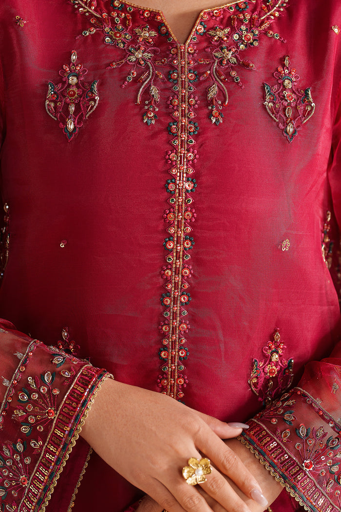 Close-up of NAQSHI deep red formal dress showing fine embroidery on neckline and front panel with premium finish