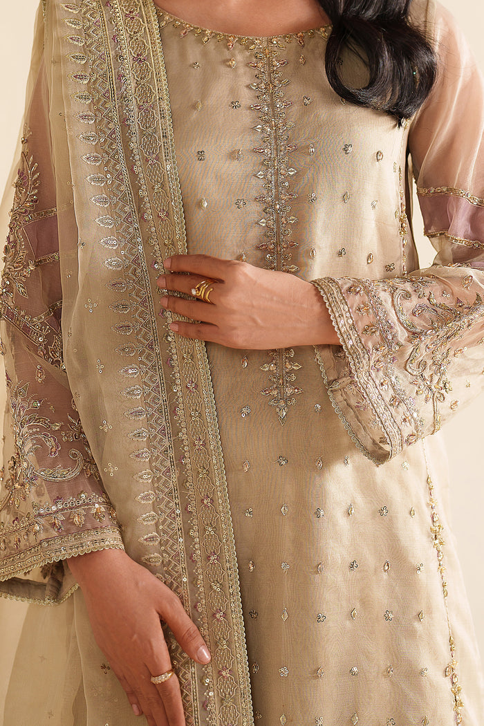 Three-quarter front view of NAQSHI ivory beige formal dress highlighting clean lines, delicate work, and refined occasion styling