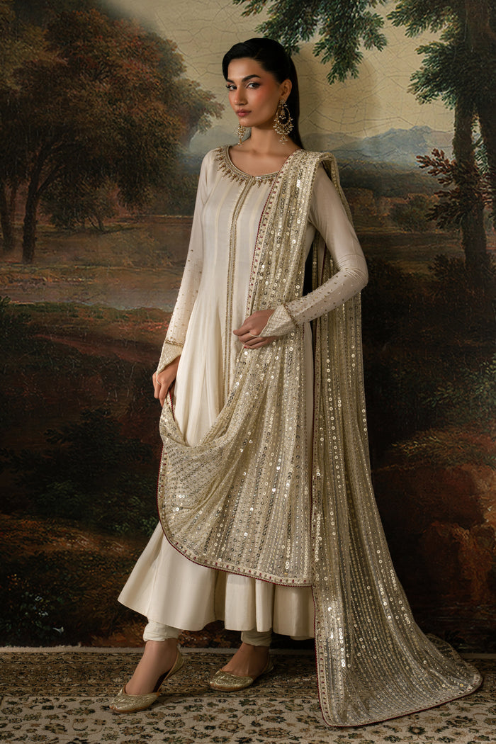 Full-length view of Zarsanga showing the off-white flared frock, churidar pajama and embroidered Net dupatta with detailed border.
