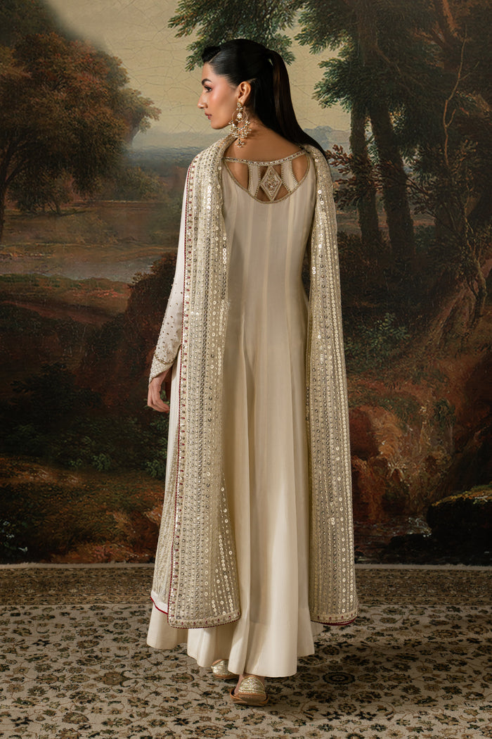 Back view of Zarsanga showing the stylized back neckline, extended sleeves and long off-white Indian Raw Silk frock.