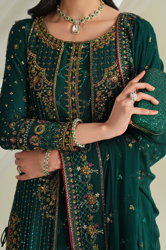 Close-up of bottle green formal gown showing detailed embroidery, neckline design, and sleeve border work.